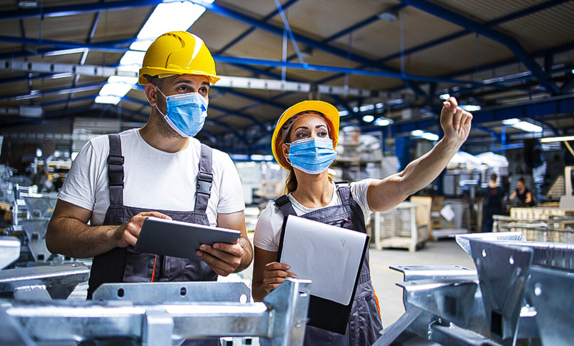 Factory workers with face masks protected against corona virus d